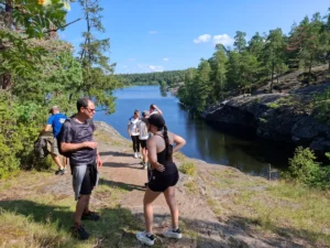Eine kleine Gruppe genießt einen sonnigen Stopp an einem friedlichen See im Nacka Naturreservat.