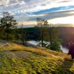 A peaceful golden hour view, overlooking the forest and lake on a late-season nature walk.