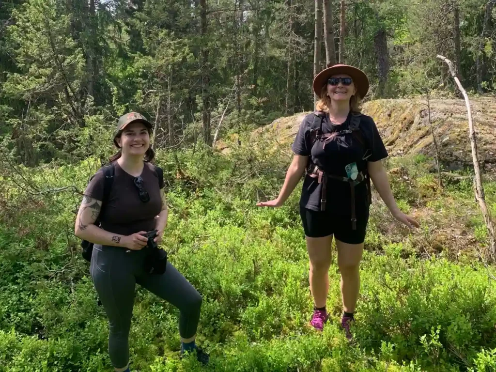 Deux clients se tenant au milieu de baies bleues lors d'une randonnée près de Stockholm.