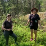 Deux clients se tenant au milieu de baies bleues lors d'une randonnée près de Stockholm.