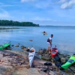 Blick auf den Stockholmer Schärengarten, während Kajakfahrer an Land gehen