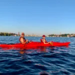 Kayakistas flotando por aguas tranquilas con vistas panorámicas del perfil de Estocolmo.