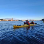 Crossing Riddarfjärden Bay by kayak with open water and the Stockholm skyline ahead
