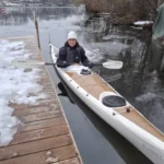 Launching a kayak from a wooden dock on a cold winter day in Stockholm