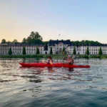 Excursión en kayak en la hora dorada con siluetas y reflejos sobre las aguas de Estocolmo.