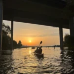 Remar hacia el atardecer bajo los puentes en una tranquila excursión en kayak por Estocolmo